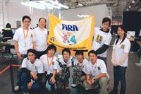 電機系師生於FIRA賽後合影，後排左二為指導教授翁慶昌，前為人形機器人。（電機系提供）