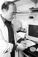 陳銘凱拿著手中的蛋白質培養皿，研究其免疫能力及抗癌基因的表現。