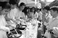 園遊會人潮眾多，印尼僑生現場製作「蛋包麵」，民眾排隊等著購買熱騰騰的風味美食，一飽口福。（記者郭展宏攝）
