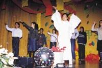 技術學院秘書邱榮金（前站者），在歲末聯歡會中，打扮成愛神邱比特，穿著白色羽毛裝，載歌載舞，詼諧逗趣的演出，讓全校師生對他刮目相看。（記者陳國良攝影）