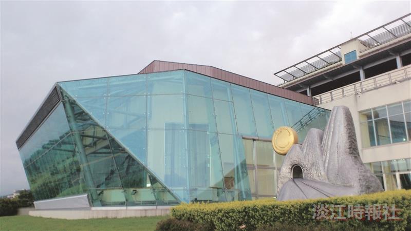 以玻璃帷幕為建築特色的強邦國際會議廳，其側之草坪上，是「蘭陽心•淡江意•雪山情」的楊英風「雪山隧道」雕塑。