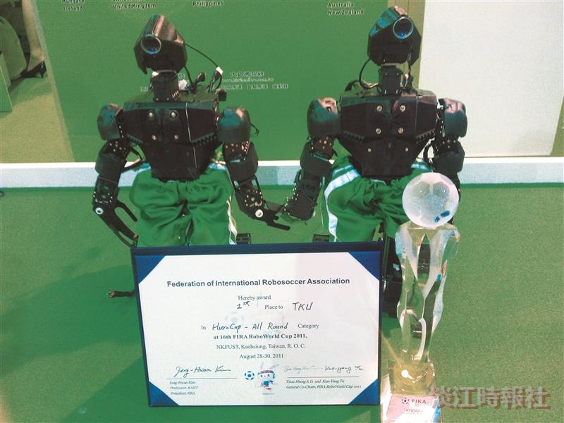 World Cup winning robots created by the TKU Robot Research Team hold hands at the Taipei International Robot Show (TIROS).