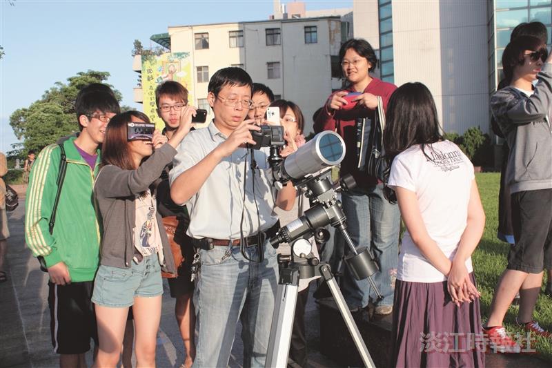 同學們圍繞在物理系助理教授秦一男（左二）觀賞日環食。（攝影／賴意捷）