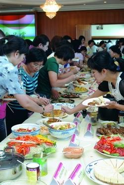 女聯會上週四舉辦「國際美食饗宴」，充滿異國風味的美食擺滿整桌，同仁各個吃得津津有味。（攝影�王文彥）