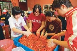 Students roll up their sleeves and learn how to make kimchi, a favorite and most well-known dish in Korea