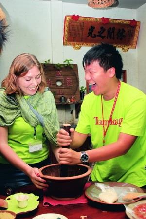 Jovita Susanna from Austria (left), a freshman of Dept. of International Trade, making Hakka ground tea happily with Cheng Chiang-fan, a junior of Dept. of Chemistry.