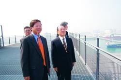 創辦人張建邦（左二）在校友總會會長陳慶男（左一）的陪伴下，前往慶富集團營運總部頂樓，參觀綠建築設備及眺望遠景。（攝影�馮文星）