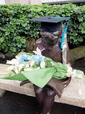 開心的畢業生忍不住與「閱讀的少女」分享喜悅之情，為她戴上學士帽，還獻花給她，邀她為畢業的見證者。（圖�劉瀚之）