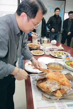 Dr. Chieh-cheng Huang, Chair of GIAS, skillfully cut the turkey, and shared it with teachers and students.