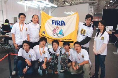 Teammates took a photo after wining the FIRA World Cup championship. Dr. Ching-chang Wong (Back left two). The android stands in front of the teammates.