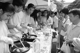 園遊會人潮眾多，印尼僑生現場製作「蛋包麵」，民眾排隊等著購買熱騰騰的風味美食，一飽口福。（記者郭展宏攝）
