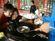 烹飪社同學在上週覺軒花園教室現場炸豆腐，香味四溢，吸引同學聞香來品嚐。（記者張佳萱攝影）