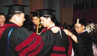 校長及院長一一為博士畢業生整理帔巾、移帽穗，頒授學位。（記者陳震霆攝）