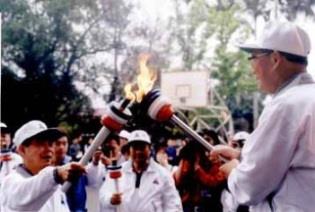 張創辦人將聖火分別引燃給主跑的校長，圖為林雲山前校長，中為張紘炬校長。